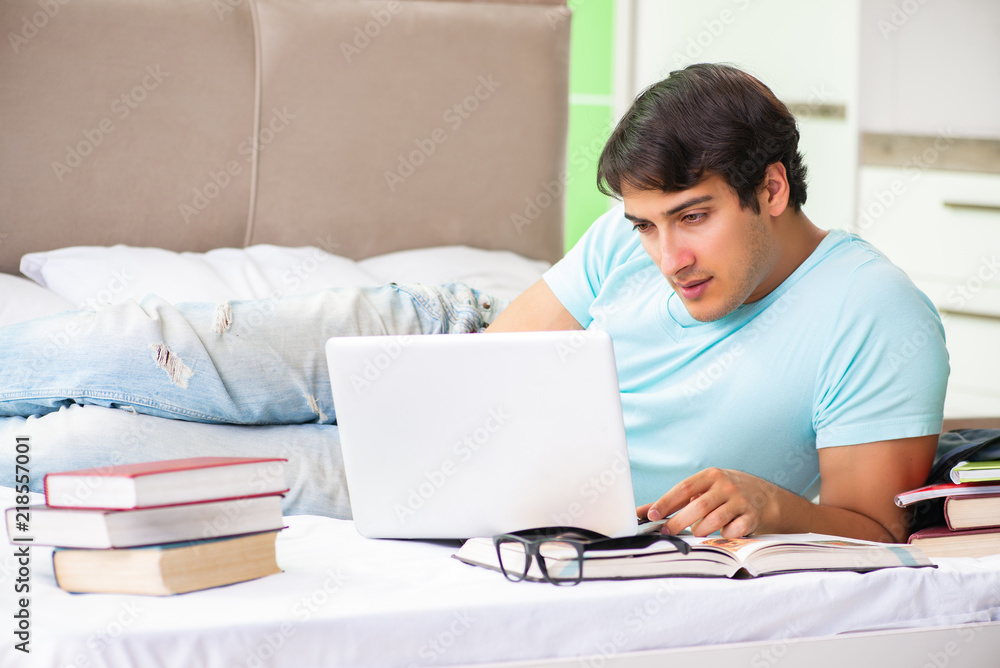 Student preparing for exams at home in bedroom lying on the bed Student preparing for exams at home in bedroom lying on the bed