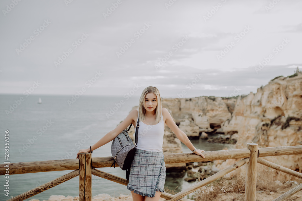 Young woman with backpack Traveler on background beach seascape horizon. Tourist look on blue sun ocean, summer lifestyle