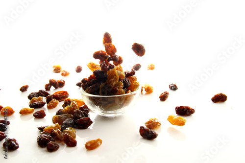 Raisins on white background   A raisin is a dried grape. Raisins are produced in many regions of the world and may be eaten raw or used in cooking  baking  and brewing