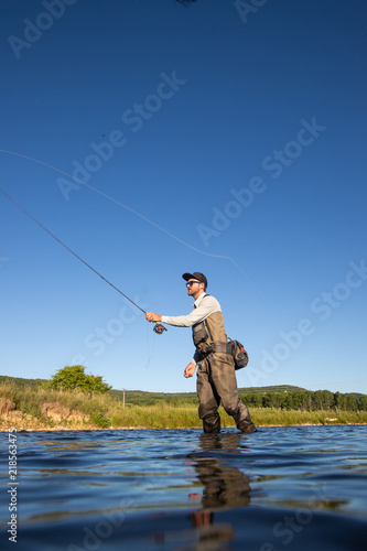Obraz na płótnie Over underwater shot of a man fly fishing in the summer in a river w salonie