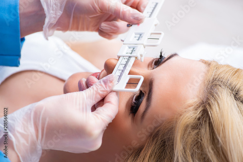 Female ophthalmologist is checking up female patient in eye doct photo