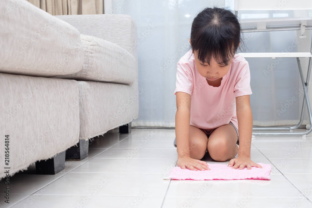 Asian Chinese little girl helping doing cleaning with rag Asian Chinese little girl helping doing cleaning with rag