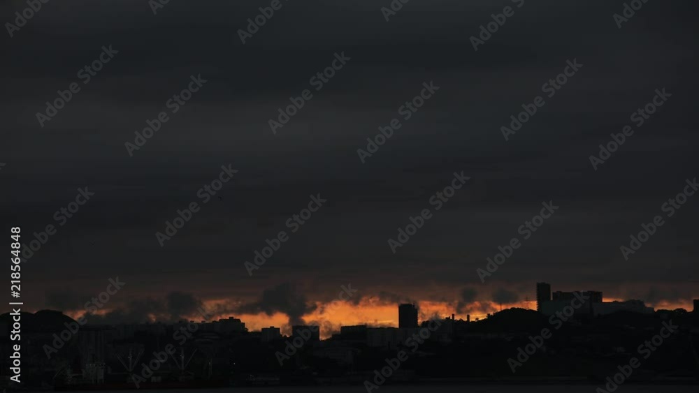 Dawn in Vladivostok, time-lapse. Silhouettes of apartment houses against the backdrop of the rising sun Dawn in Vladivostok, time-lapse. Silhouettes of apartment houses against the backdrop of the rising sun