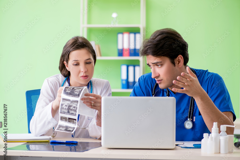 Woman and man gynecologists discussing medical case at the clini Woman and man gynecologists discussing medical case at the clini