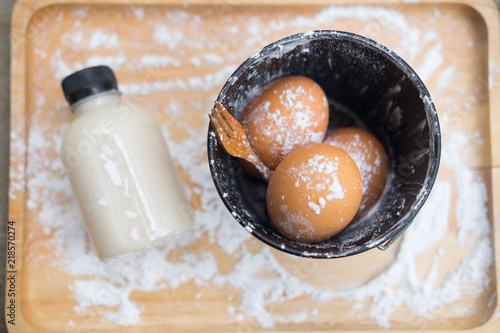 Flour and eggs on wooden background
