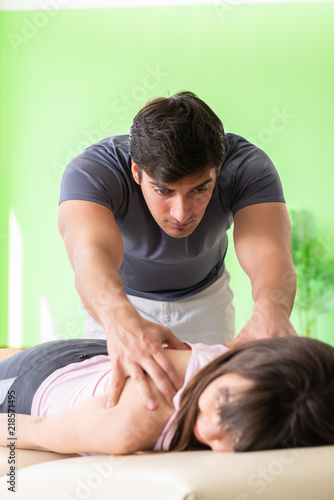 Young doctor chiropractor massaging patient 