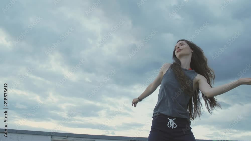 urban female dancer waving her hips and dancing in sunset blue sky urban female dancer waving her hips and dancing in sunset blue sky
