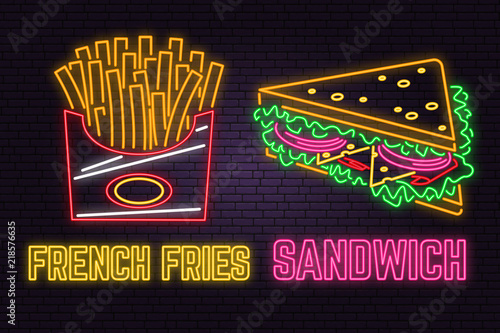 Retro neon sandwich and french fries sign on brick wall background.