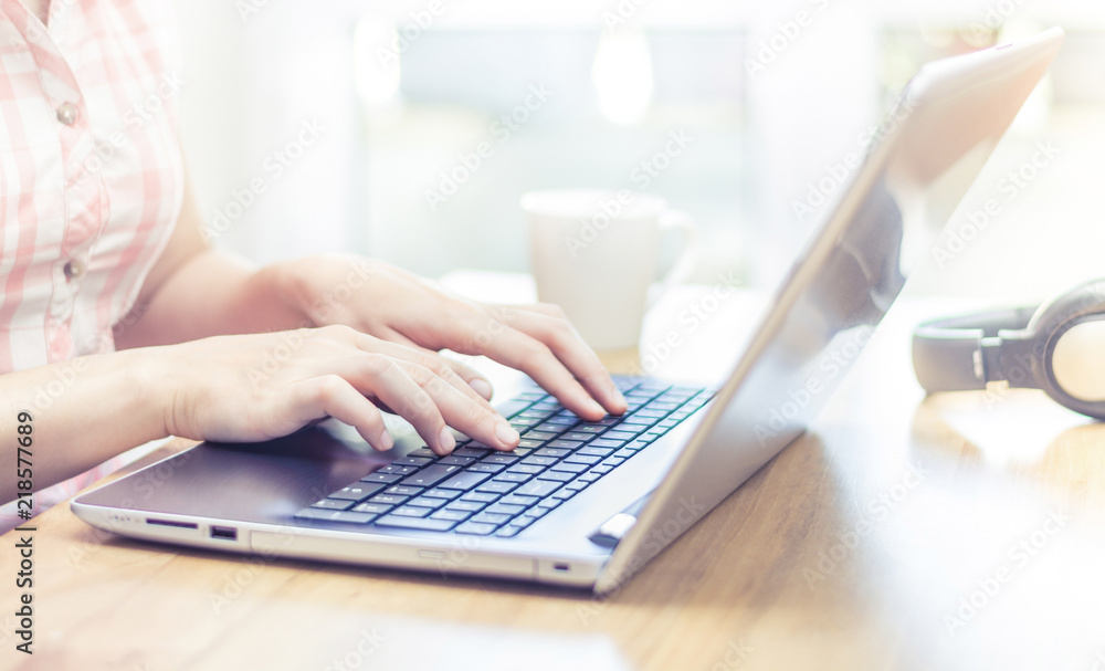 Woman sitting at desk and typing on laptop keyboard close up Woman sitting at desk and typing on laptop keyboard close up