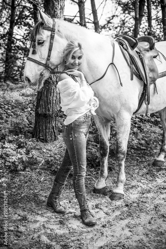 Nice scene woman with a horse in the countryside. Concept of horse and human. Portrait of vintage style artistic woman walking with horse outdoors 