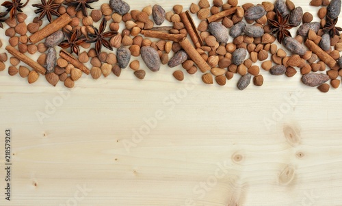  Concept with ingredients for chocolate, cocoa beans, cinnamon, anise, apricot beans on natural wood background, copy space, vertical