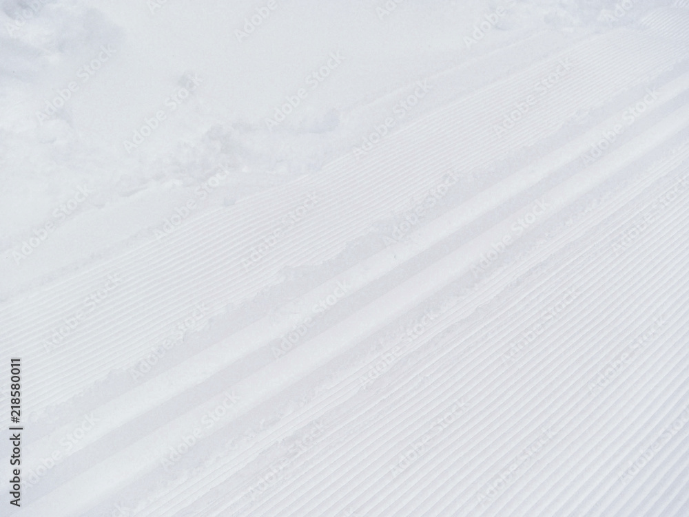 Ski track on white snow. Winter background. Snow texture