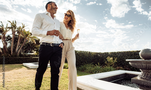 Schilderij op canvas Stylish couple walking outdoors and smiling