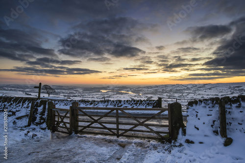 Stunning Winter sunset over snow covered Winter landscape in Peak District