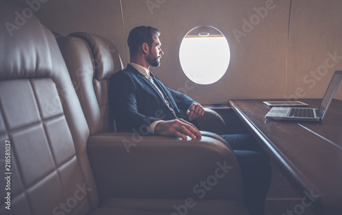 Businessman flying on his private jet. Business man flying on the private airplane. Working during the flight to his meeting. Concept about transportations and salespeople	 photo