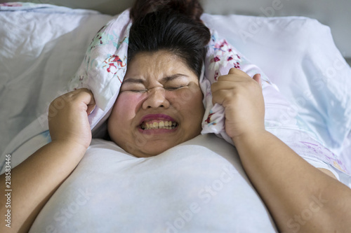 Frustrated overweight woman unable to sleep photo