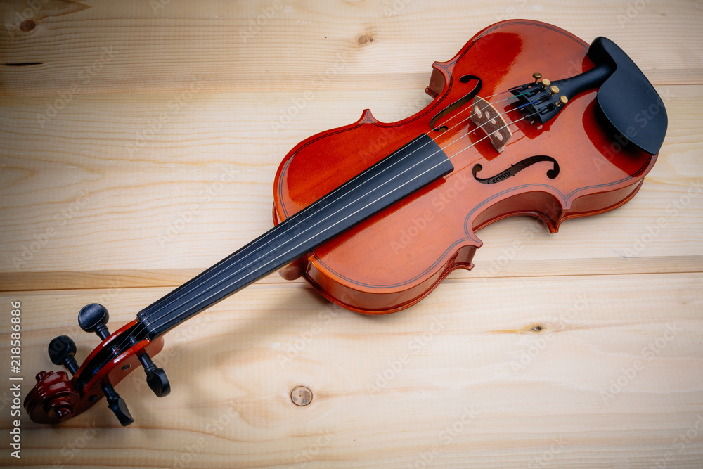 Naklejka premium the violin lies on a wooden table