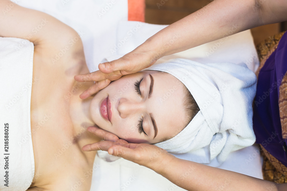 beautiful girl enjoys face massage in spa salon. Procedures for beauty and rejuvenation. Thai massage beautiful girl enjoys face massage in spa salon. Procedures for beauty and rejuvenation. Thai massage