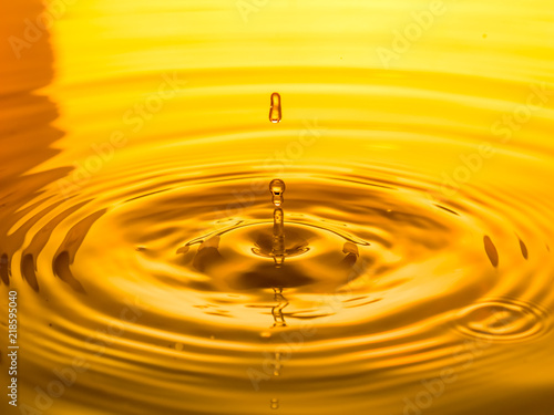 close up of a drop oil on a yellow background