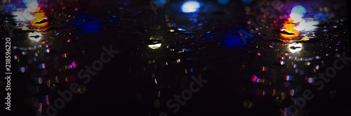 Background of wet asphalt with neon light. Blurred background  night lights  reflection.