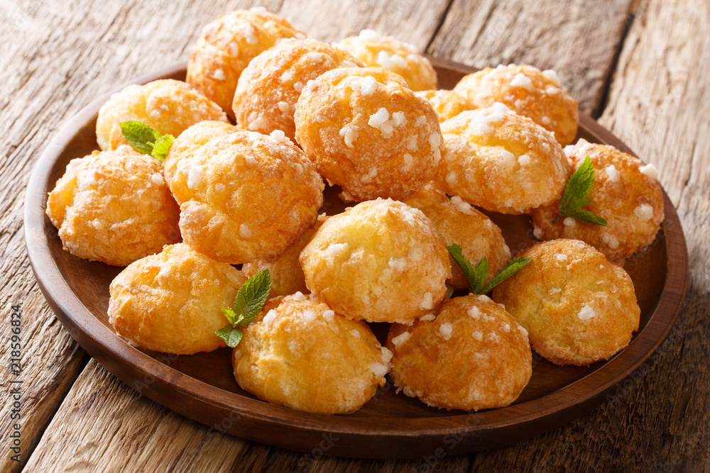French profiteroles Chouquettes with pearl sugar and mint closeup on a plate. horizontal French profiteroles Chouquettes with pearl sugar and mint closeup on a plate. horizontal