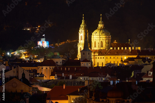 Night landscape or cityscape of historical downtown of the Prague, quarter Mala strana and rooftops, with Saint Nicolas church, oldest part of city by Prague castle