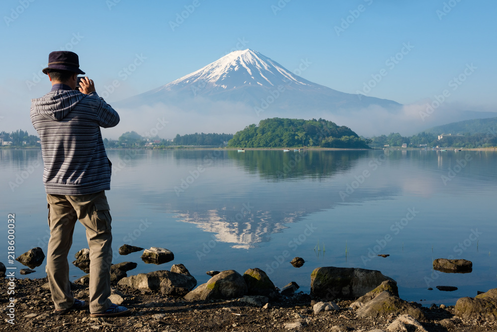 Tourist taking a photo of Mt. Fuji reflected on water Tourist taking a photo of Mt. Fuji reflected on water