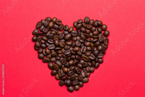Grains of coffee in the form of heart on a red background © vfhnb12