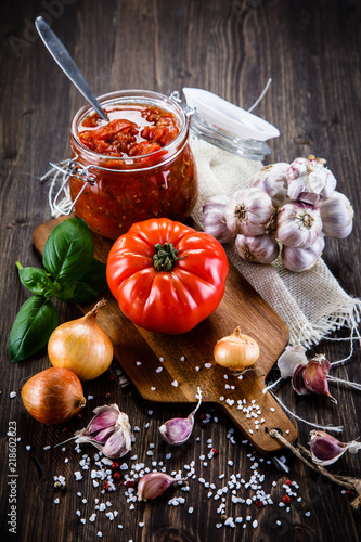 Fototapeta Naklejka Na Ścianę i Meble -  Raw tomatoes and tomato sauce in jar