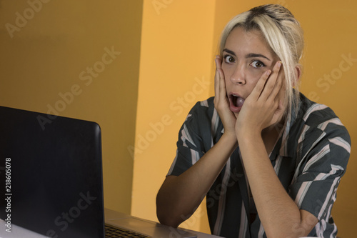 Surprised office worker reading good news on a computer photo