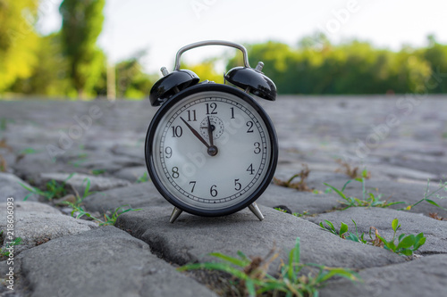 Alarm clock on old pavement outdoors