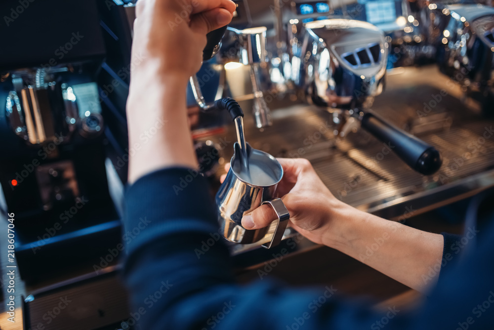 Male barista prepares beverage on coffee machine Male barista prepares beverage on coffee machine