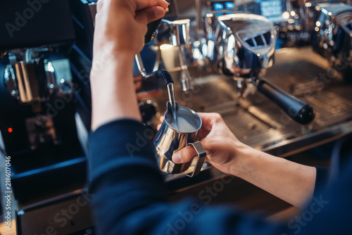 Male barista prepares beverage on coffee machine