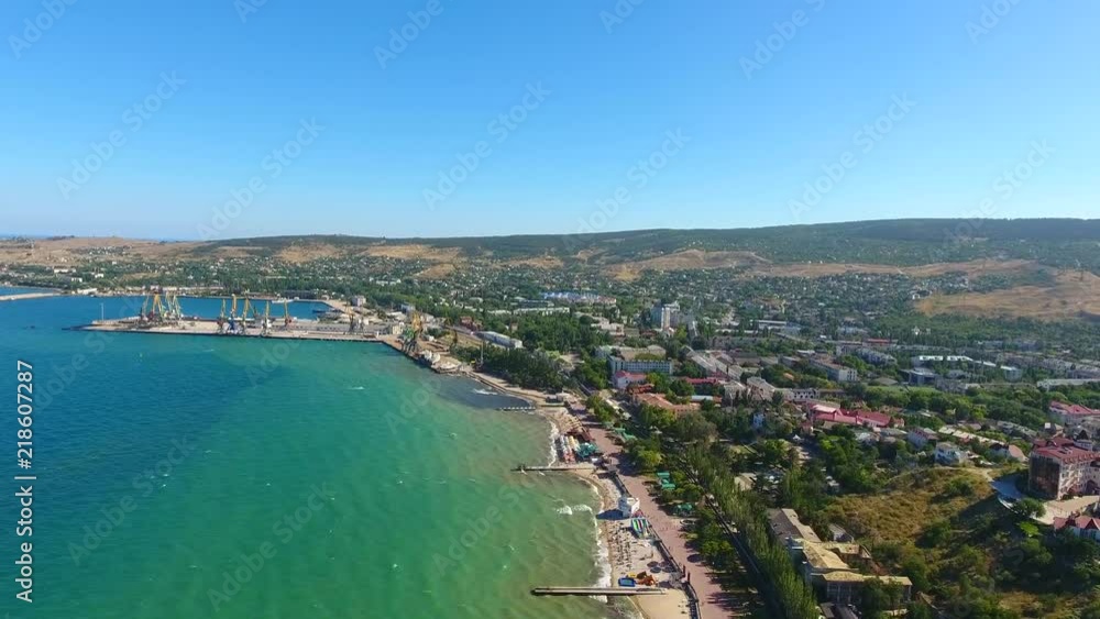 Top view: Shipping terminal Feodosia handling containers Receive port of ships, cranes, Sea, beach, laguna resort town of Feodosiya, Cremea vacation on Black sea. Dreamland beach from top view, city Top view: Shipping terminal Feodosia handling containers Receive port of ships, cranes, Sea, beach, laguna resort town of Feodosiya, Cremea vacation on Black sea. Dreamland beach from top view, city