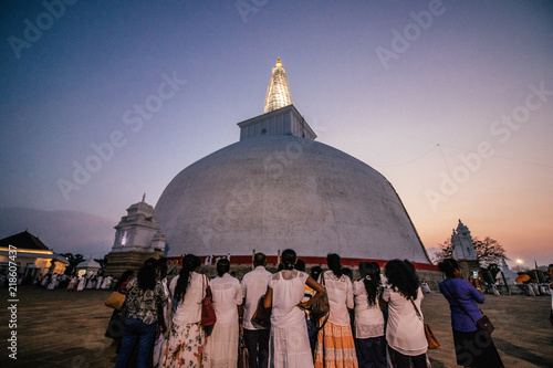 belivers worshipping in front of a stulpa temple in buddhism photo