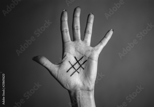 Black hashtag marked on girl's tender pale palm of hand. Close-up. Concept (idea) of the Internet, social media, networking, communication, internet addiction.