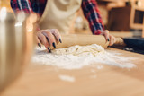Housewife rolls out the dough with a rolling pin