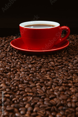 Red coffee cup with coffee beans .