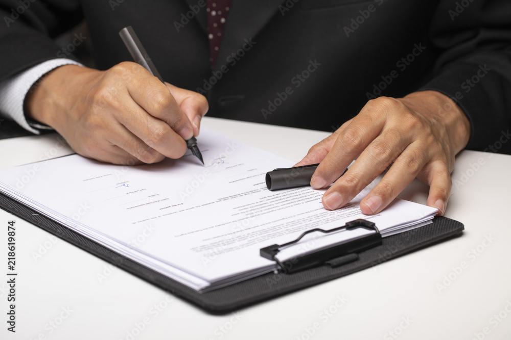 A person signing paperwork A person signing paperwork