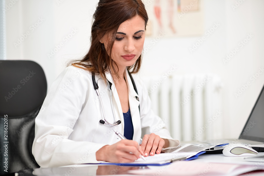 Doctor doing paperwork in her office Doctor doing paperwork in her office