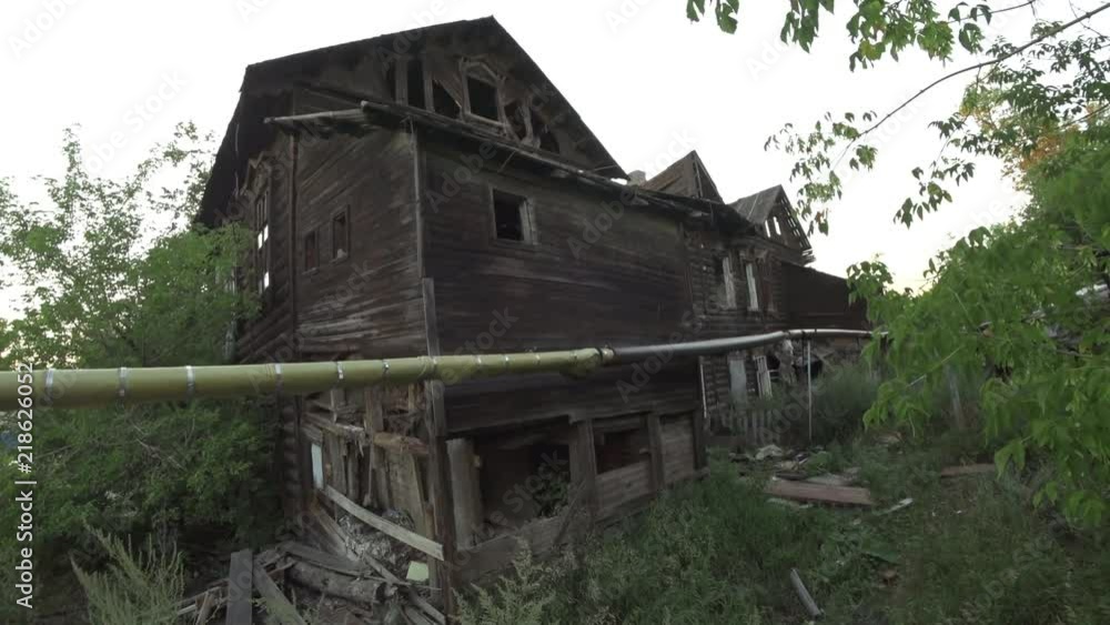 View of an old wooden ramshackle two-story phouse. View of an old wooden ramshackle two-story phouse.