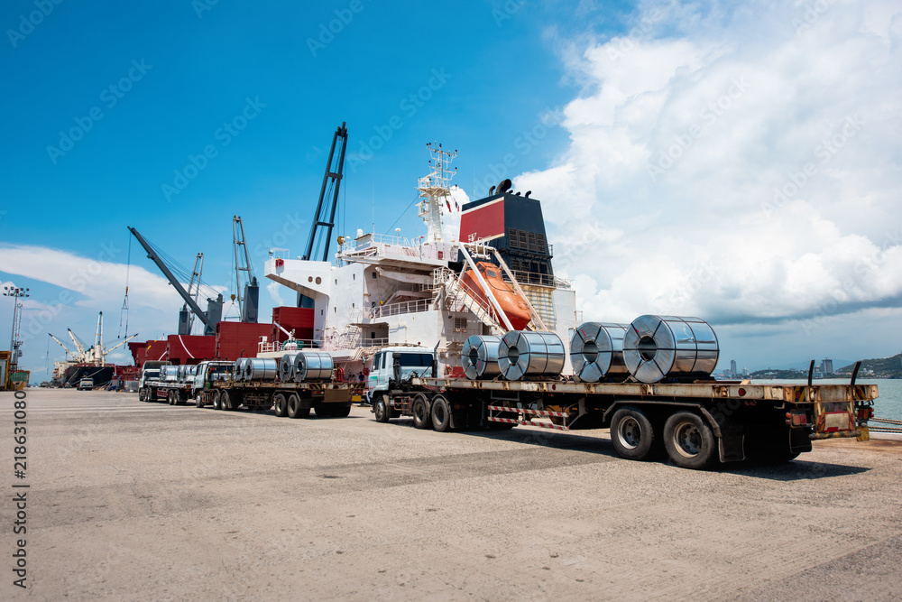 Fototapeta premium sea port terminal where both tranports meet together of sea ship and trailers trucking cargo delivery shipment from loading port to discharging destination port services to Worldwide logistics system