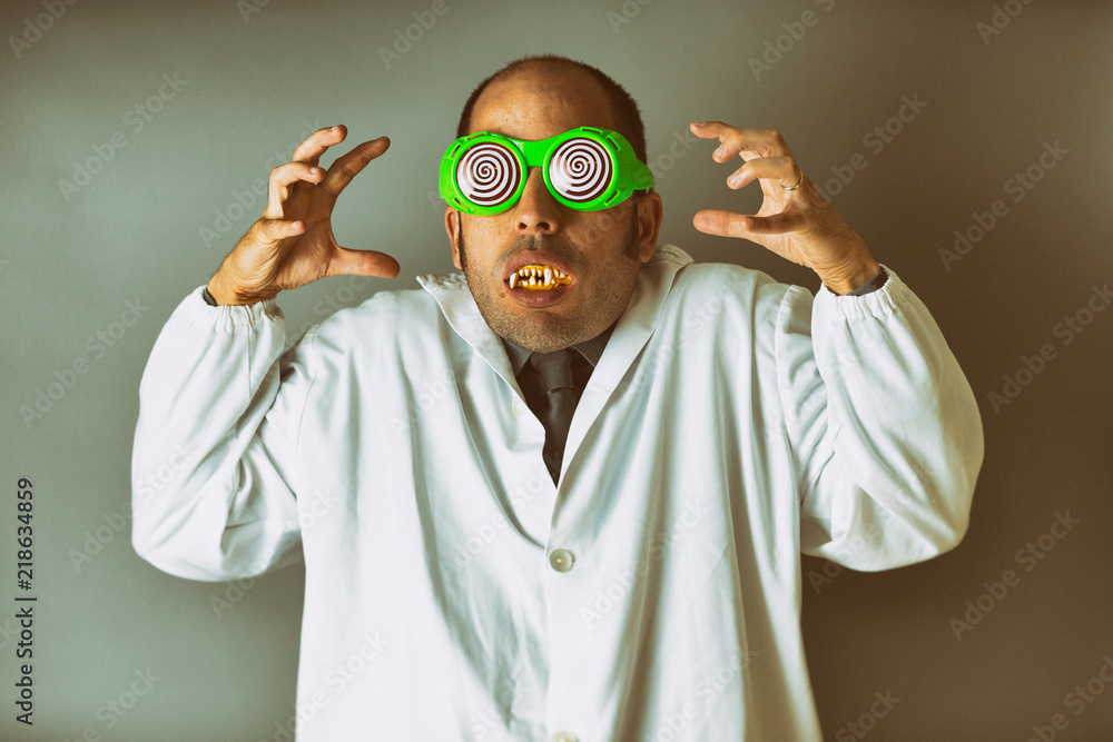 A man dressed as a mad scientist with a lab coat, crazy glasses, and vampire teeth - obrazy, fototapety, plakaty 