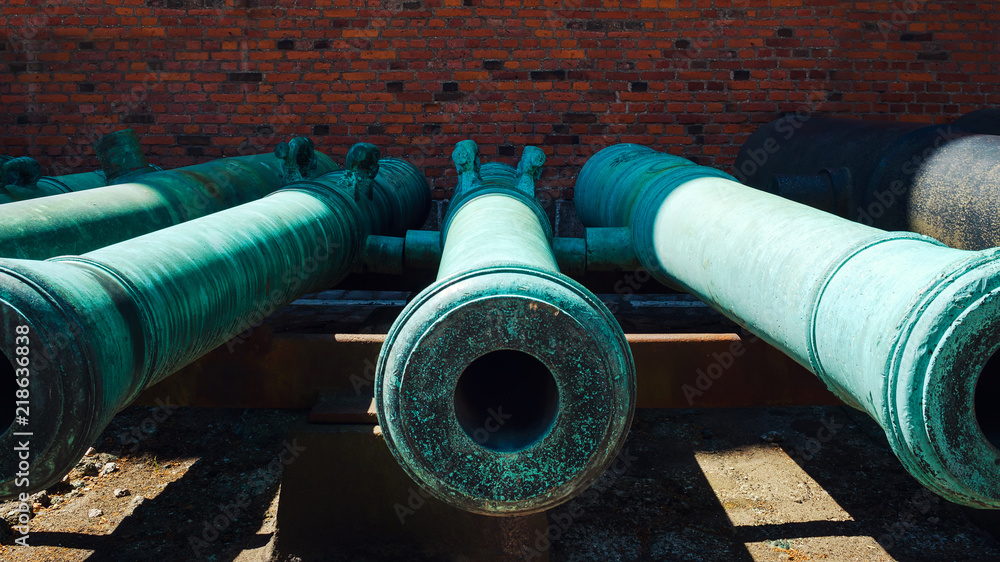 Old cannon against a brick wall. Close-up. Old cannon against a brick wall. Close-up.