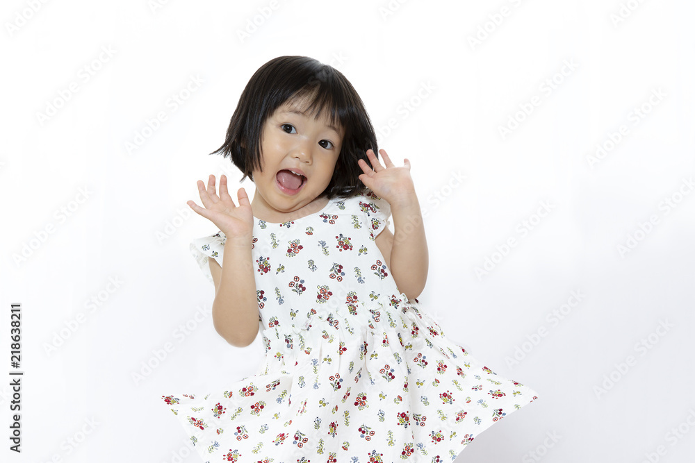 両手を上げ驚いている、ワンピースの幼い女の子。驚き、ビックリ、ショック、喜び、衝撃のポーズ 両手を上げ驚いている、ワンピースの幼い女の子。驚き、ビックリ、ショック、喜び、衝撃のポーズ