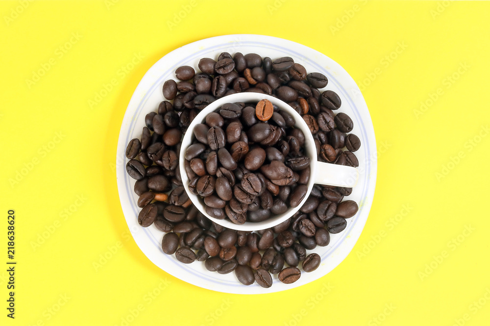 Coffee bean white ceramic cup saucer on yellow color background Coffee bean white ceramic cup saucer on yellow color background