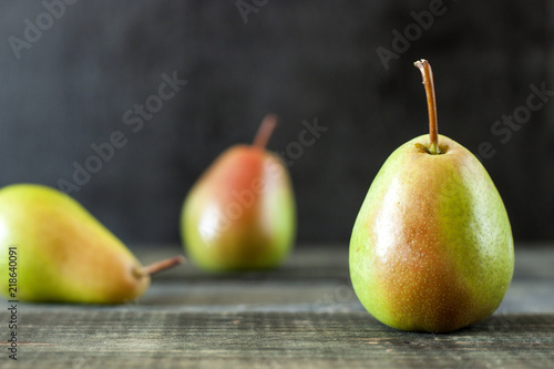 Fresh ripe pears lie on a white wooden table