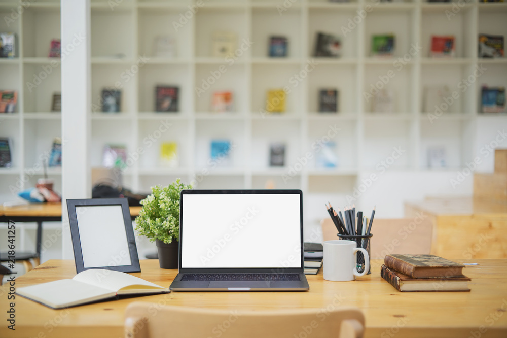 Mockup blank screen laptop on wood table in co-working space. Mockup blank screen laptop on wood table in co-working space.