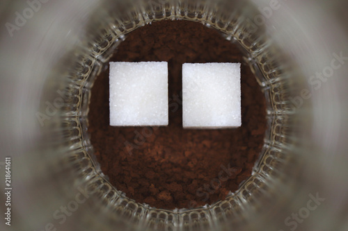 Two pieces of sugar in a glass with an insoluble coffee photo