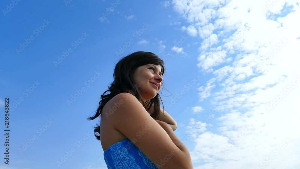 A girl is standing on the beach and looking out into the sky. A girl is standing on the beach and looking out into the sky.